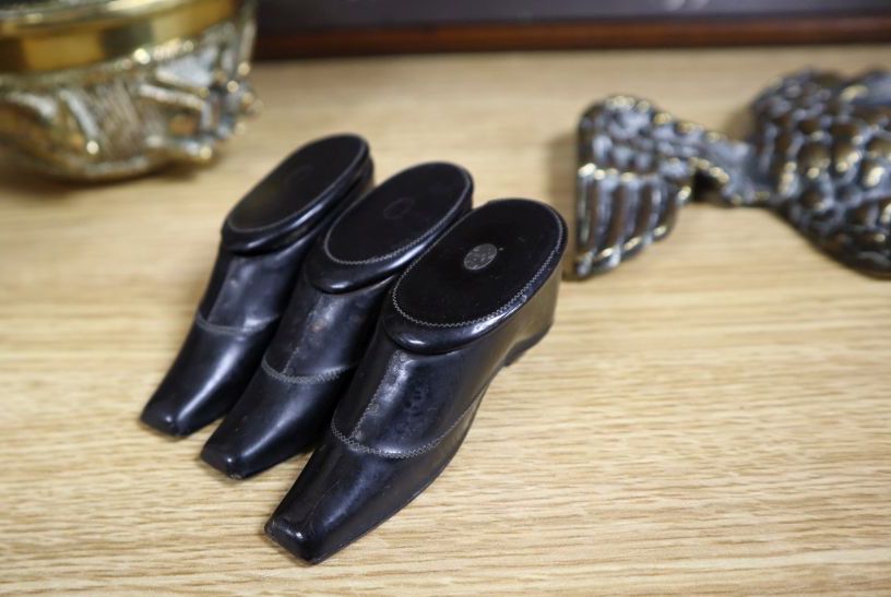 A set of three Victorian papier mache snuff boots, 8cm, a bank nameplate and ornamental brassware (8)